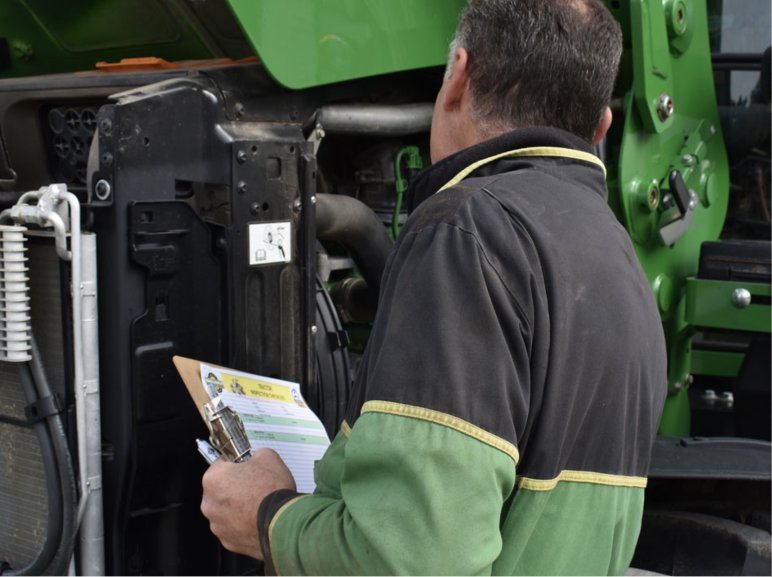 man looking at tractor